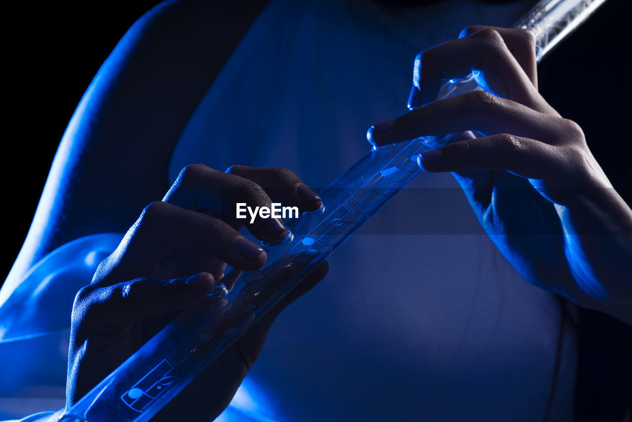 Close up of the hands of a young woman playing a crystal flute