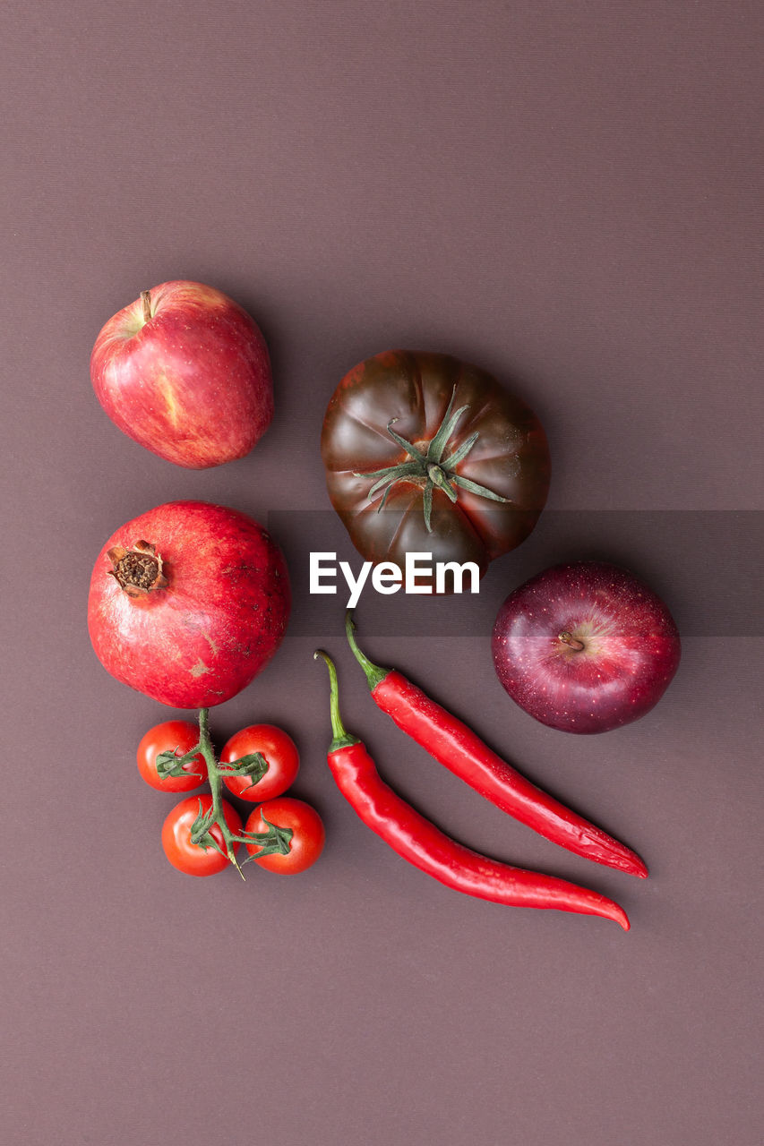 Red fruits and vegetables on brown background