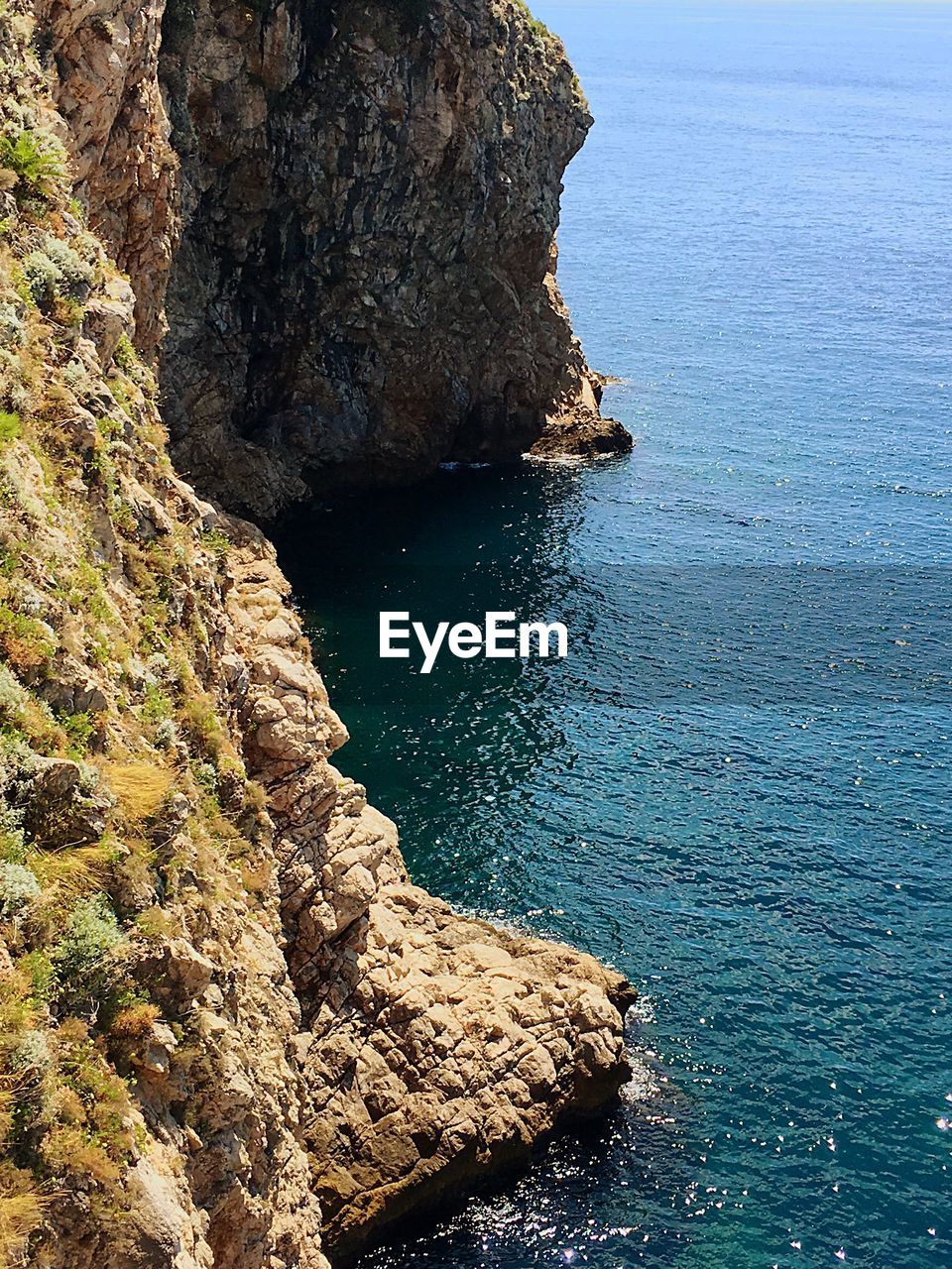 High angle view of rock formation by sea against sky