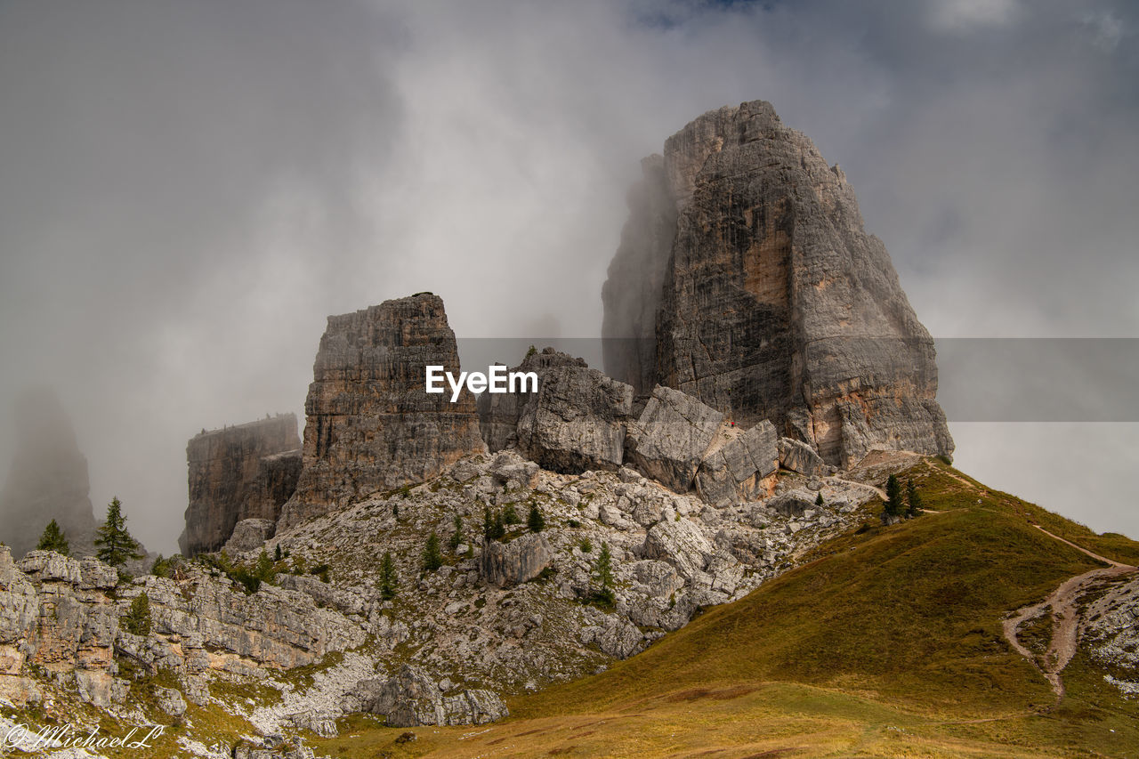 LOW ANGLE VIEW OF ROCKS AGAINST CLOUDY SKY