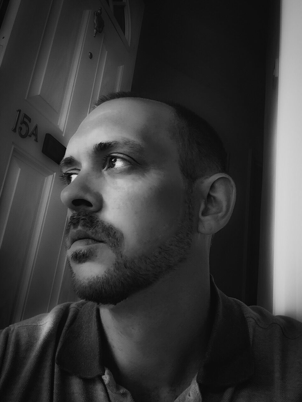 CLOSE-UP OF MID ADULT MAN AT HOME AGAINST WALL
