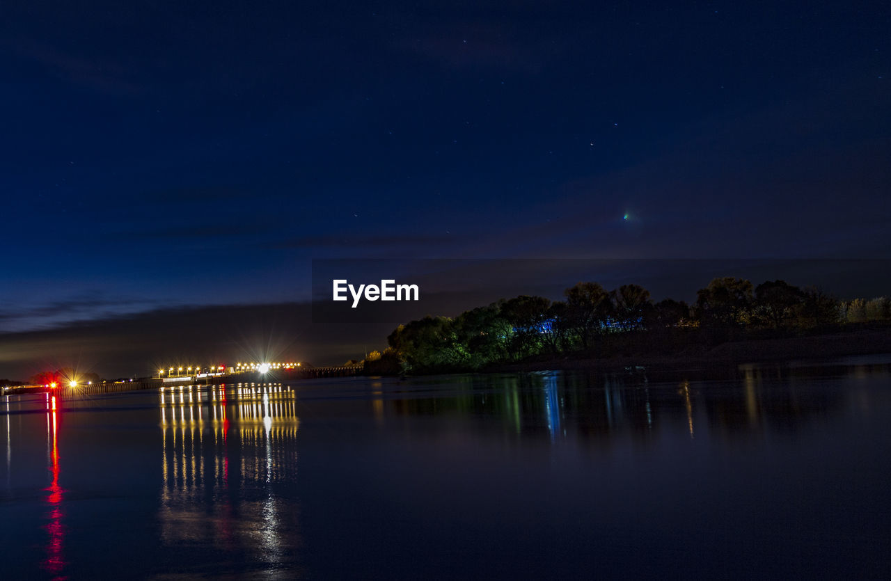 Scenic view of lake against sky at night