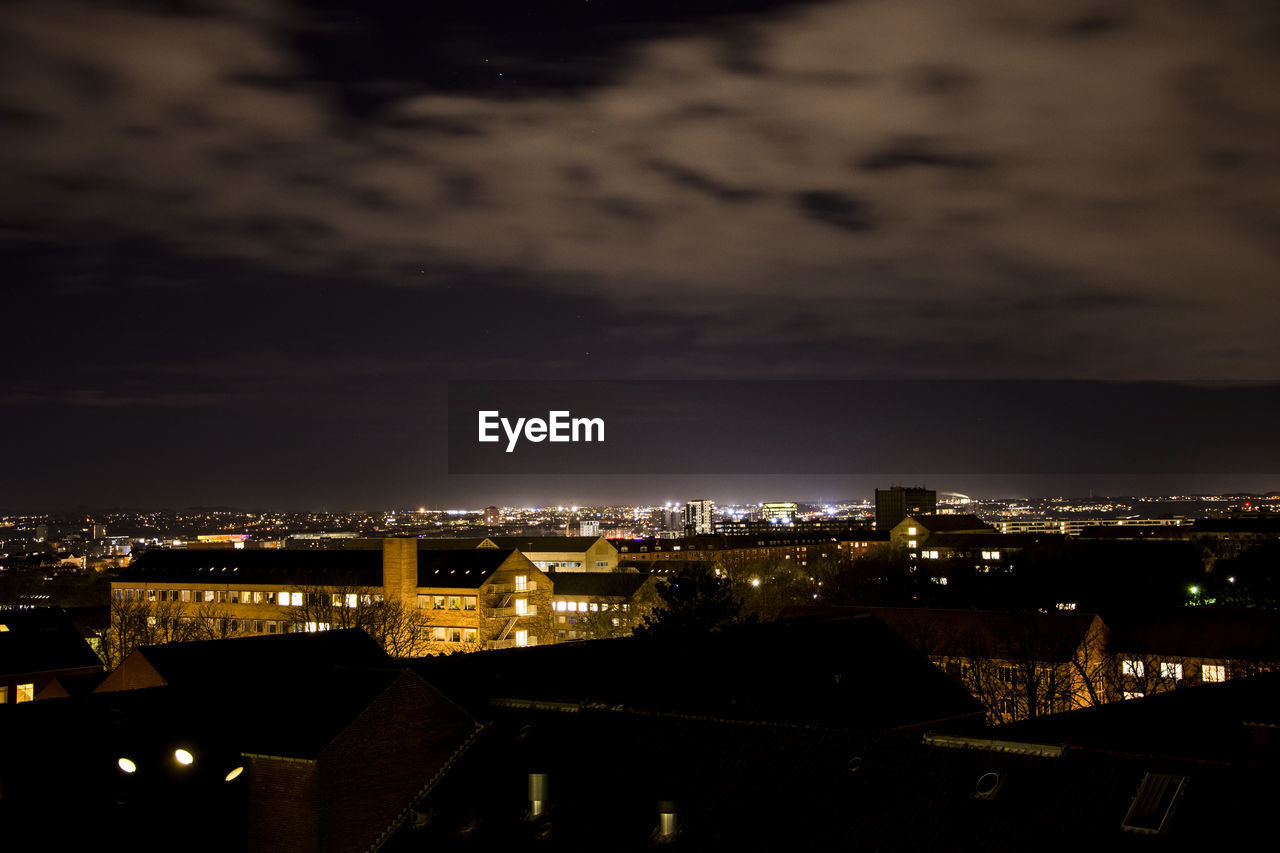 High angle view of illuminated buildings against sky at night