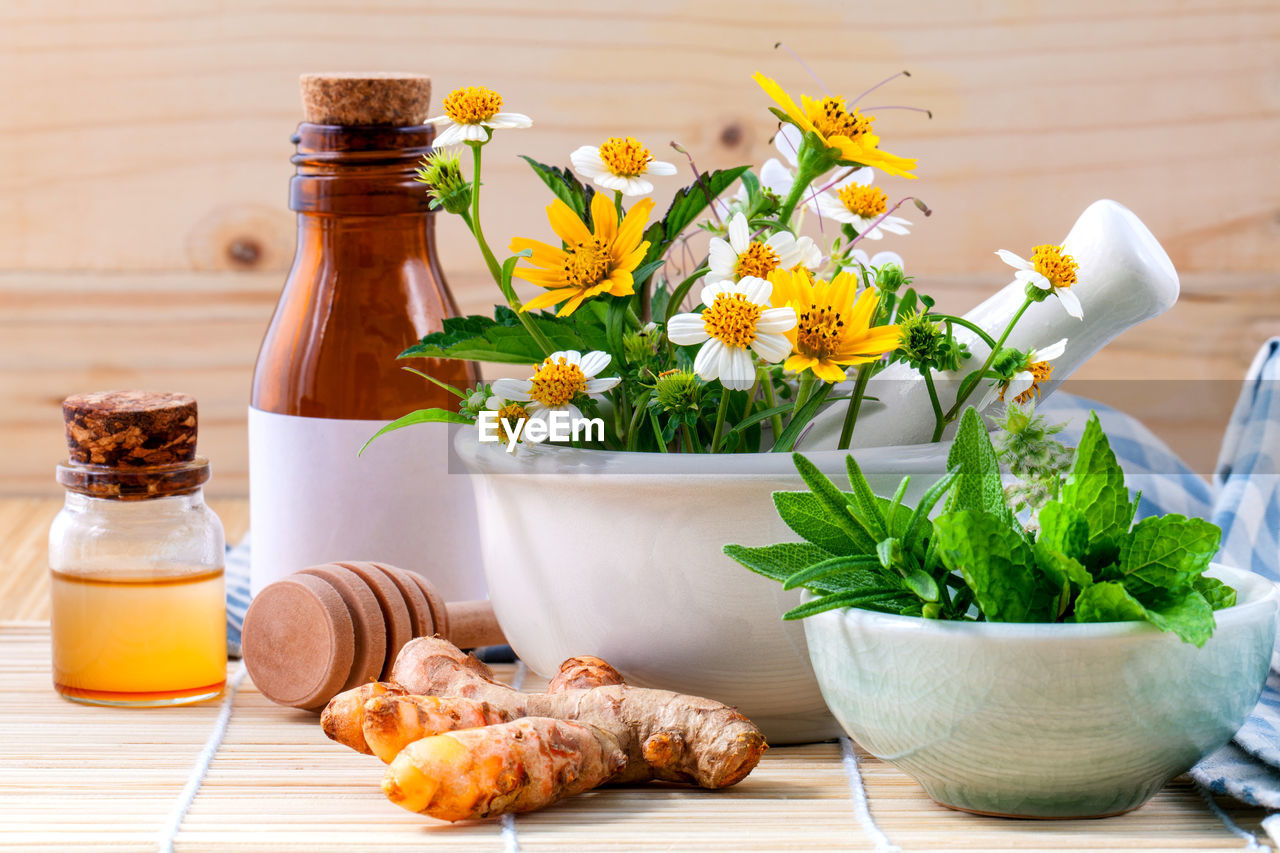 Various cooking oils in bottles by plants on table