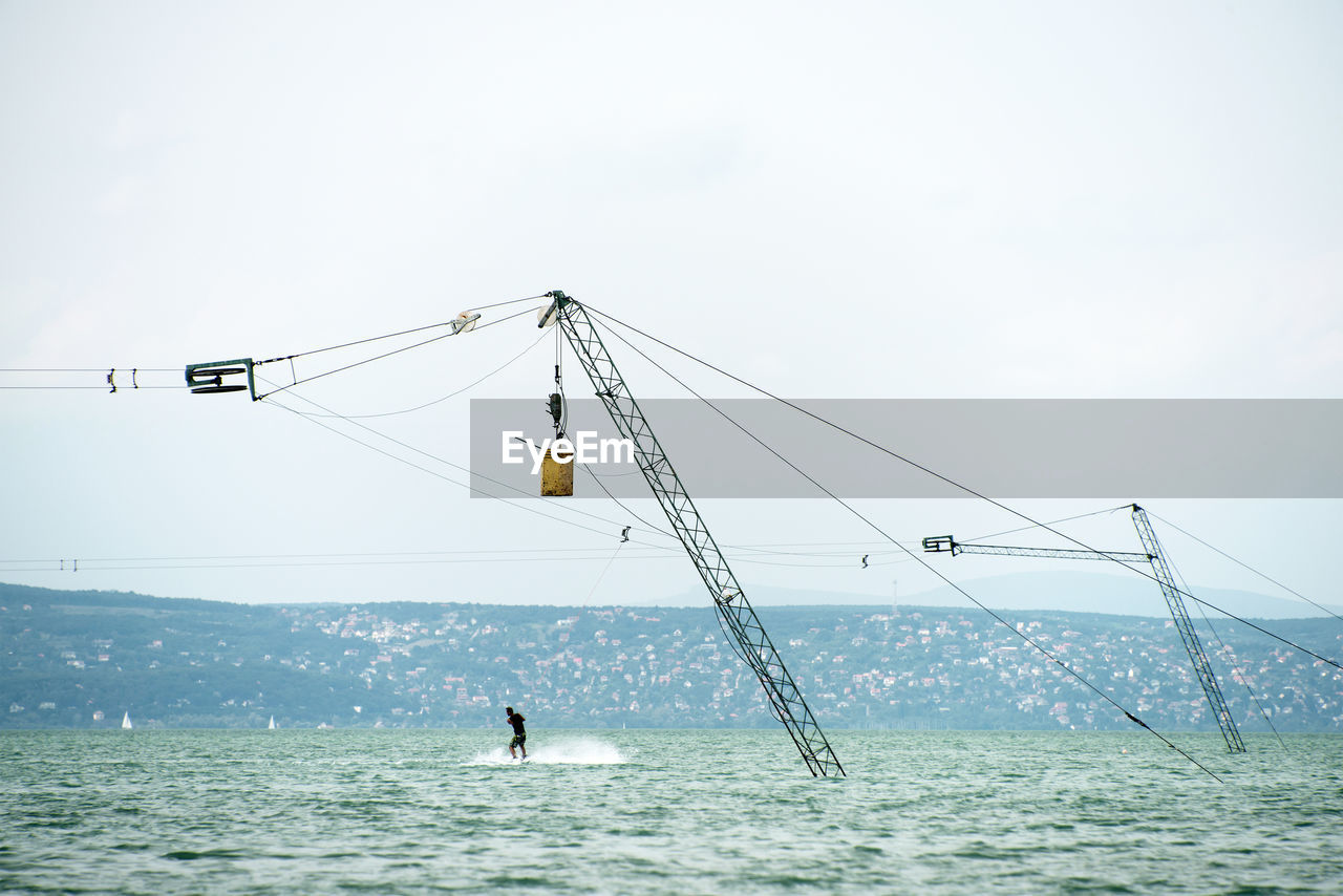 MAN OVER SEA AGAINST SKY