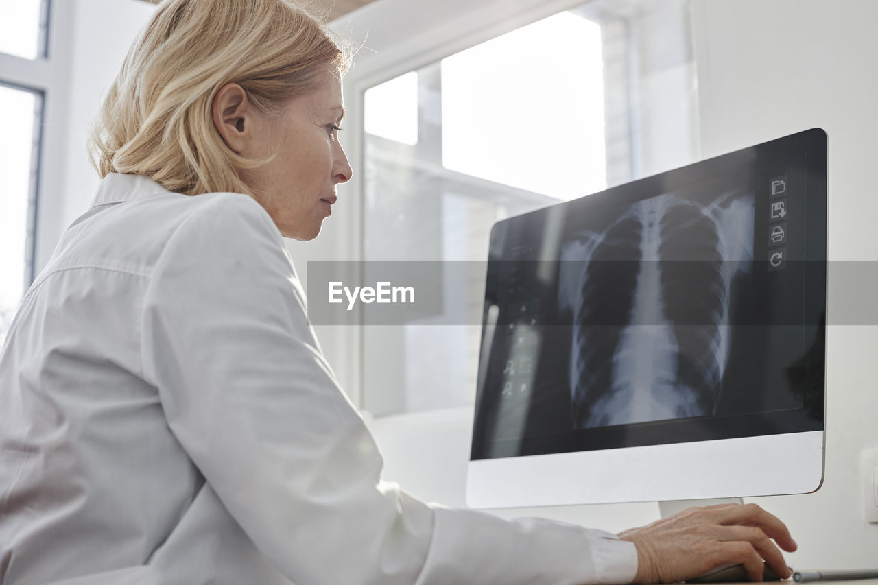 Doctor analyzing x-ray image on desktop pc in clinic