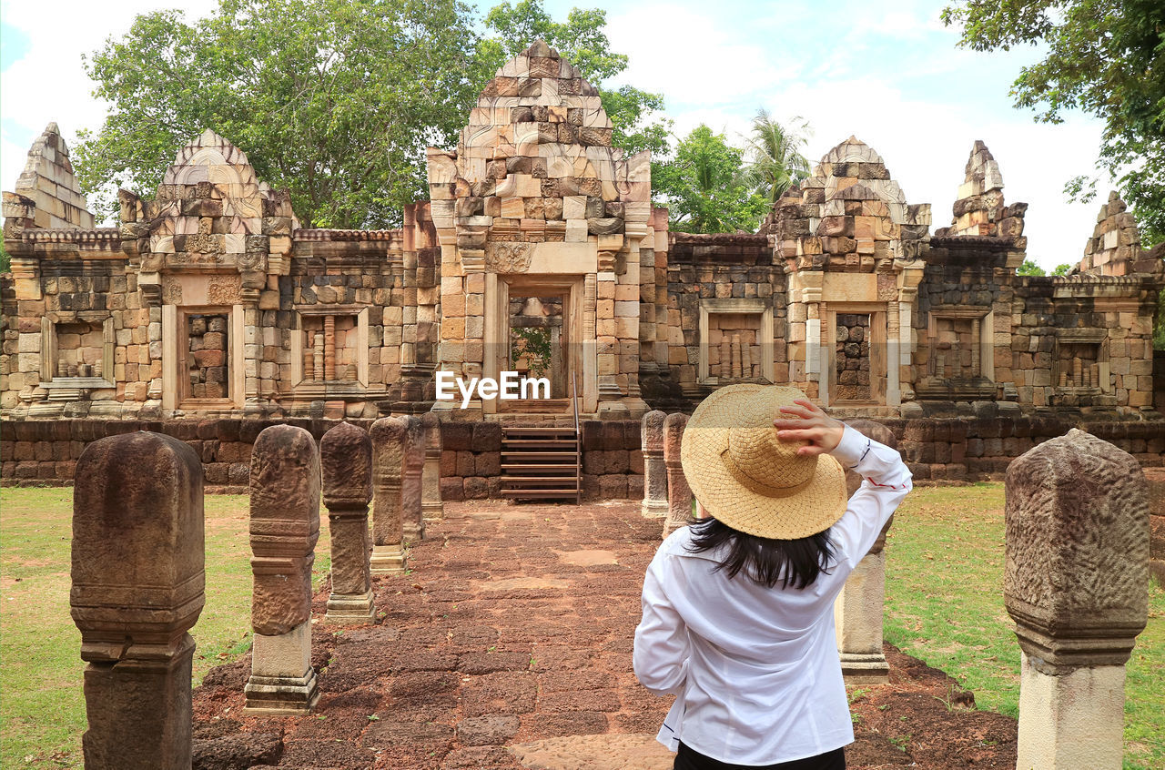 Female traveler visiting prasat sdok kok thom khmer temple complex in sa kaeo province, thailand