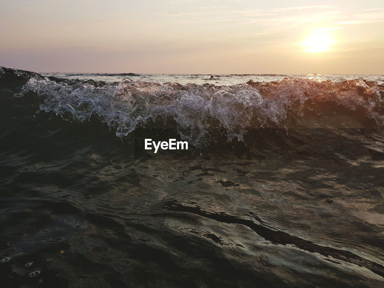 PANORAMIC VIEW OF SEA WAVES AGAINST SKY DURING SUNSET