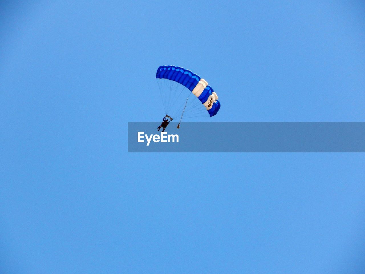 LOW ANGLE VIEW OF PEOPLE PARAGLIDING AGAINST CLEAR SKY