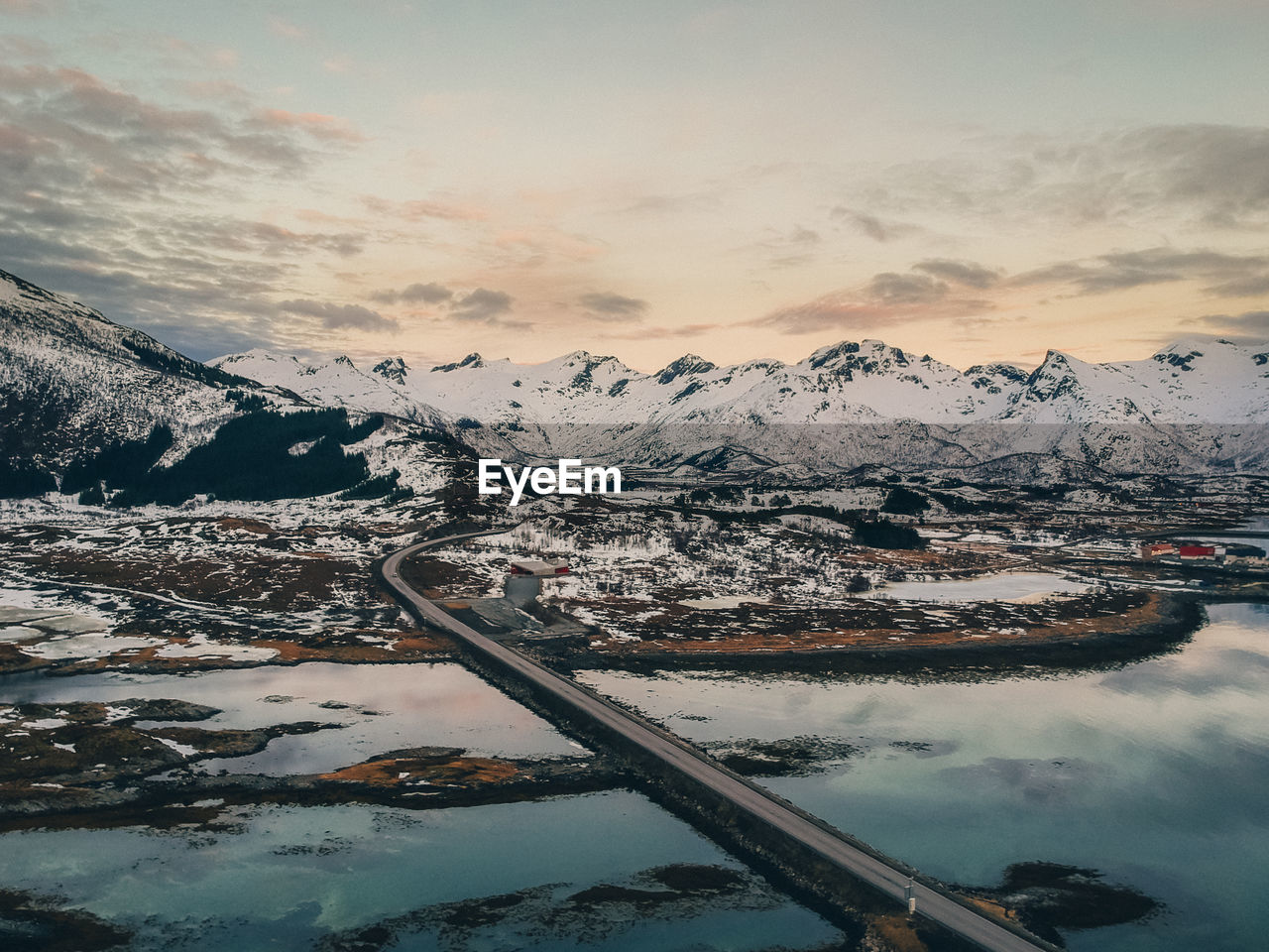 Aerial view of snowcapped mountains against sky during sunset