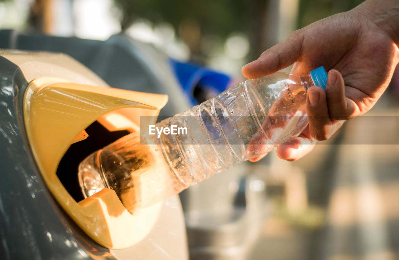 CLOSE-UP OF HAND POURING WATER IN BOTTLE