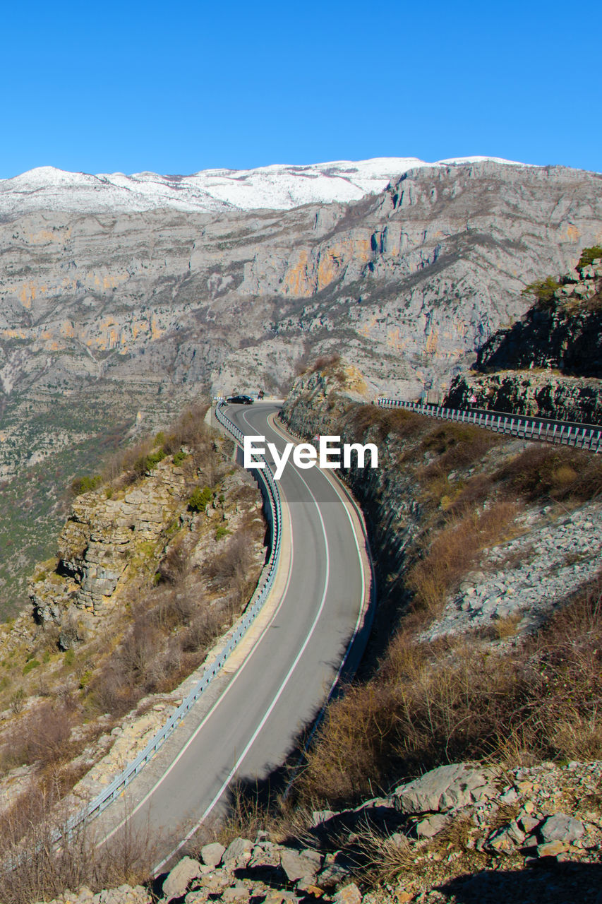 HIGH ANGLE VIEW OF WINDING ROAD ON MOUNTAIN