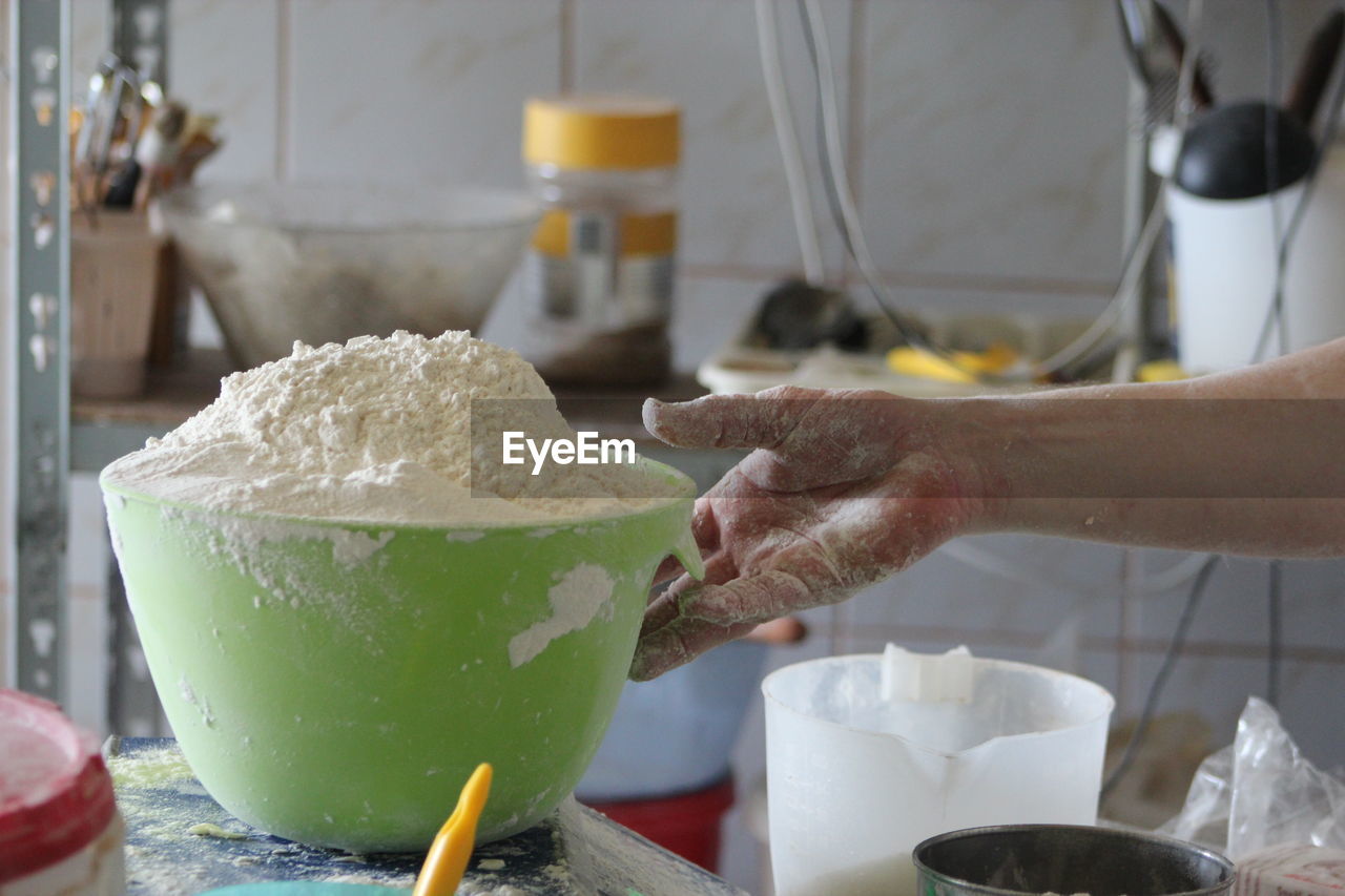 Flour measurement with light green bowl in bakery on a sunny day to make flour salt water bread