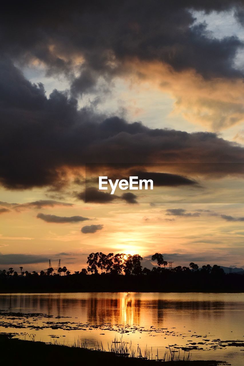 SCENIC VIEW OF LAKE AGAINST DRAMATIC SKY