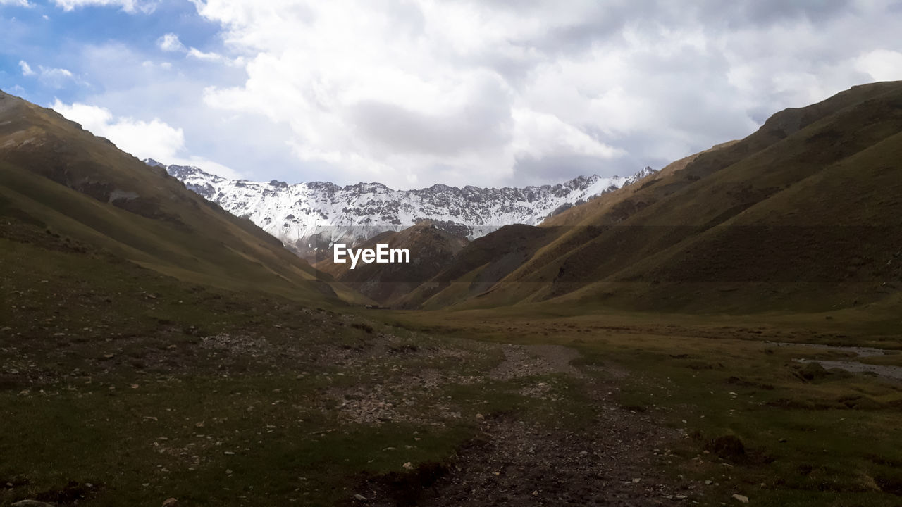 PANORAMIC VIEW OF SNOWCAPPED MOUNTAINS AGAINST SKY