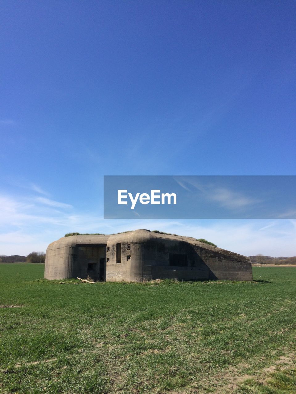 Barn on field against blue sky