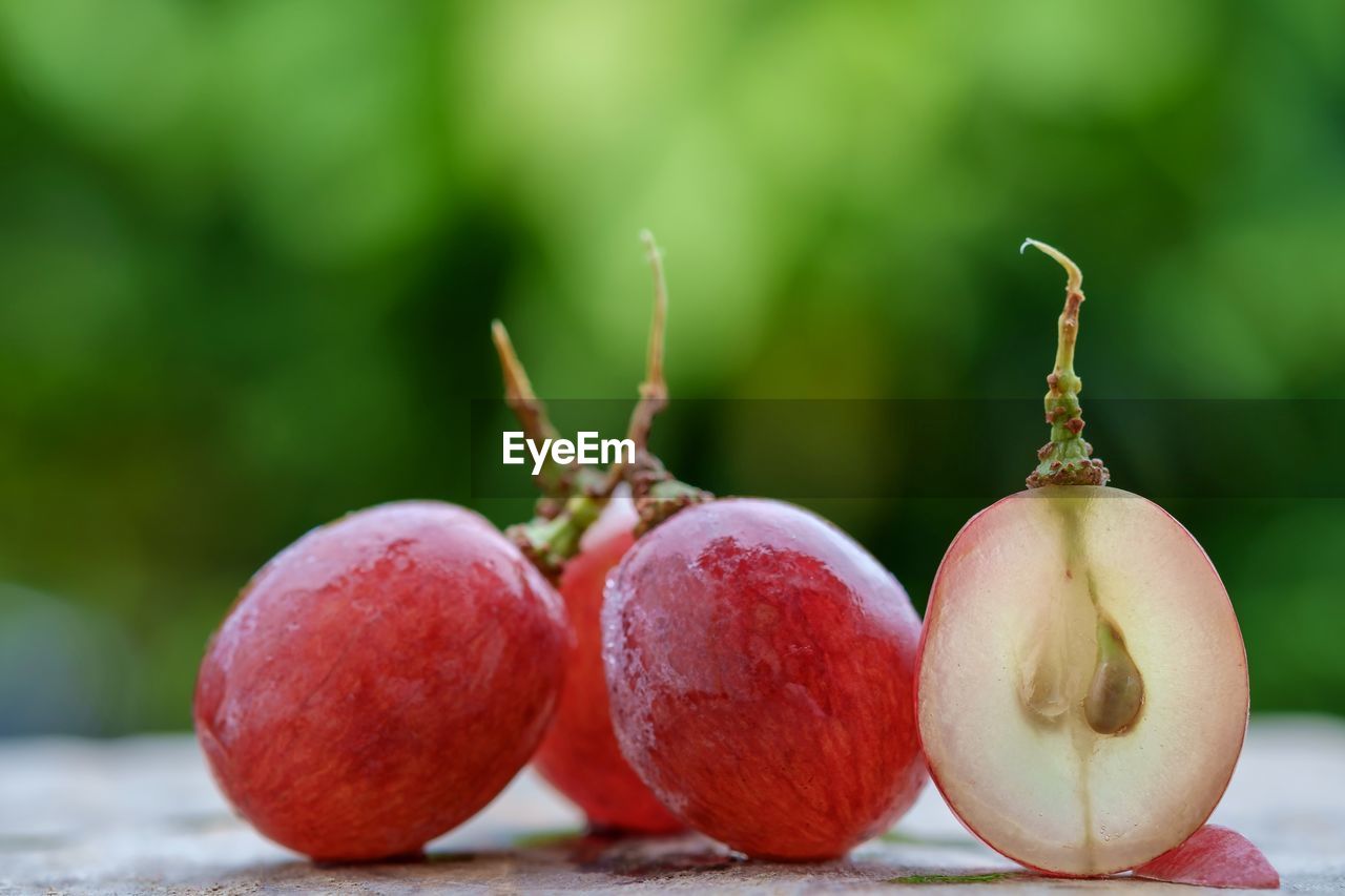 Close-up of red grapes on table outdoors