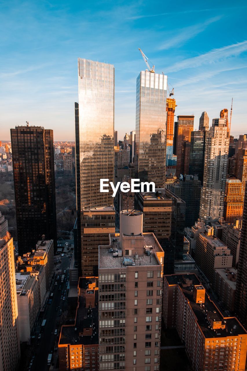 HIGH ANGLE VIEW OF MODERN BUILDINGS AGAINST SKY IN CITY