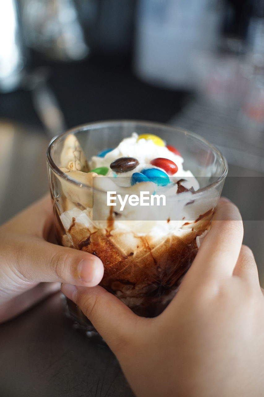 MIDSECTION OF PERSON HOLDING ICE CREAM IN GLASS