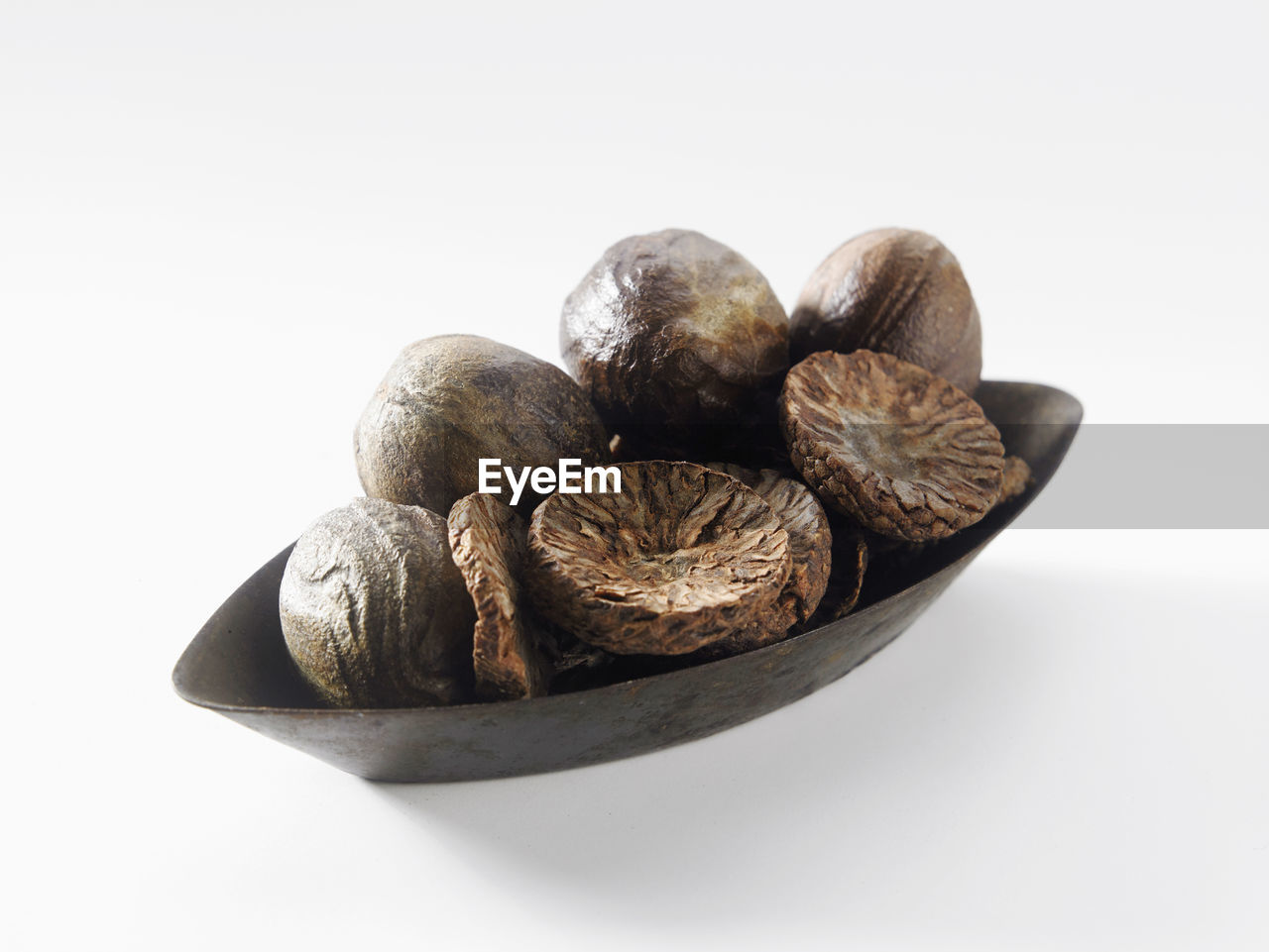 Close-up of dried food in bowl over white background