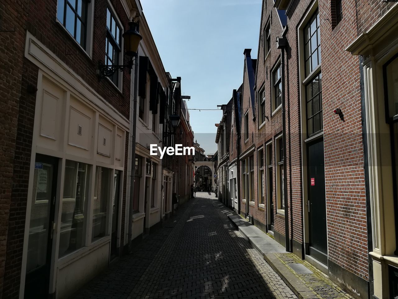 Narrow street amidst buildings against sky