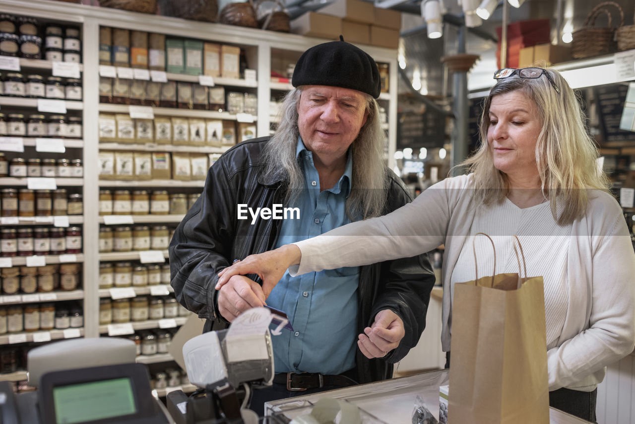 Senior couple using self-checkout at store