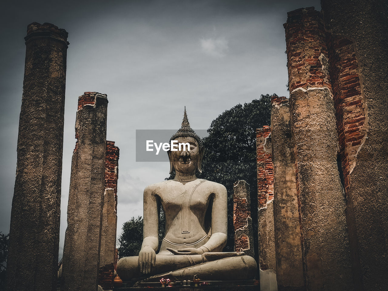 STATUE OF BUDDHA AGAINST BUILDINGS