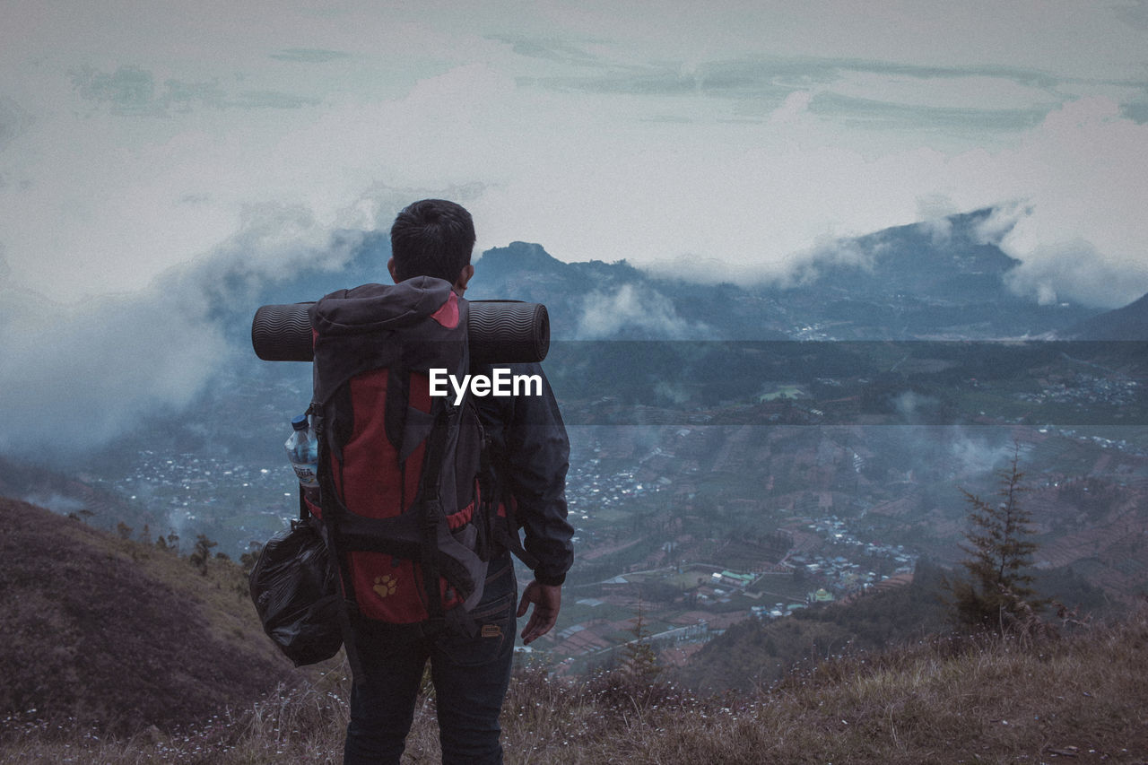 Rear view of man standing on mountain