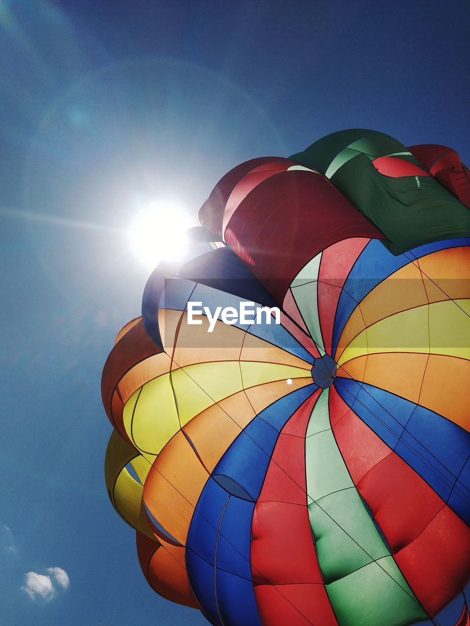 Low angle view of parachute against sky on sunny day