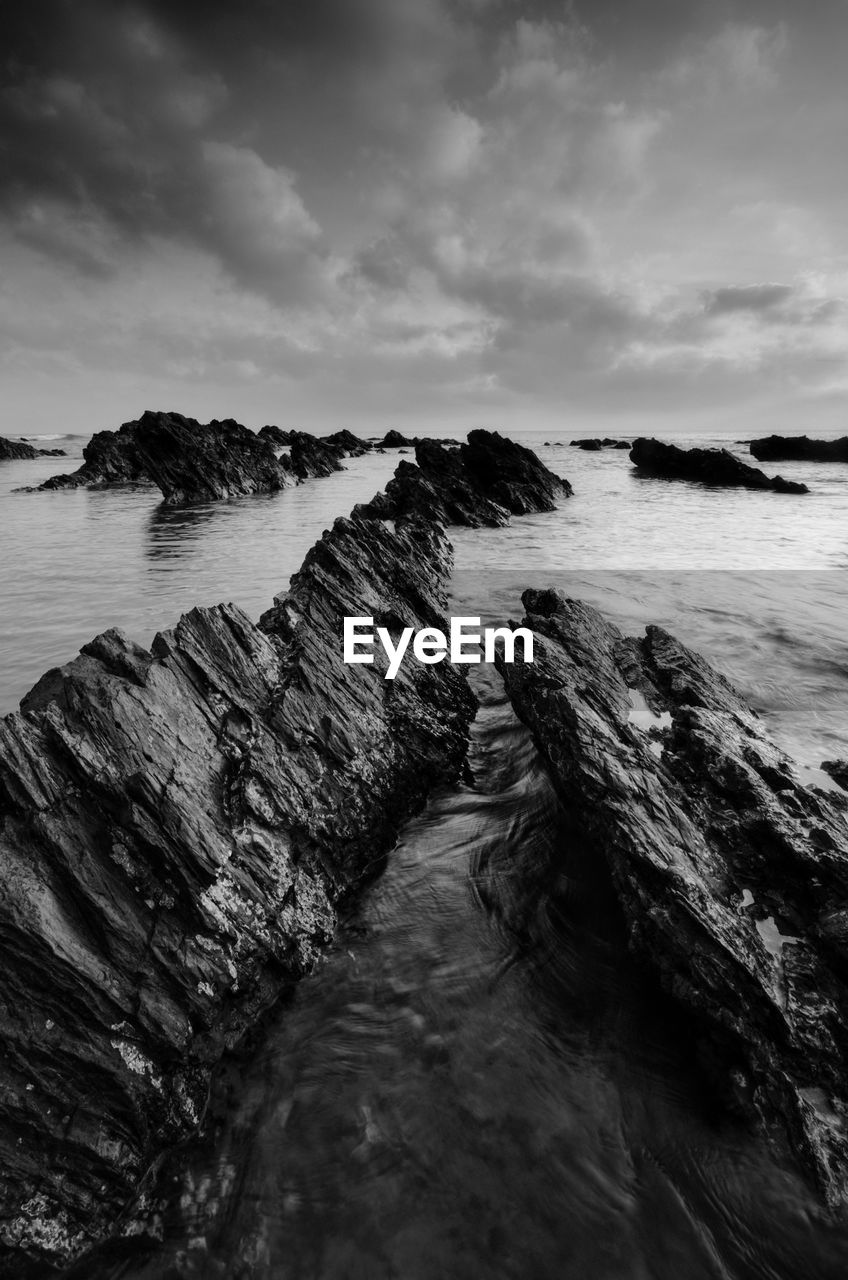 Scenic view of rocks on beach against sky