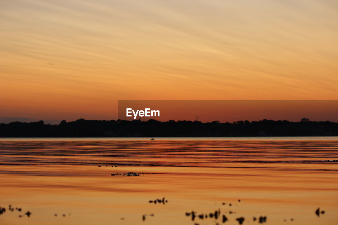 Scenic view of lake against sky during sunset