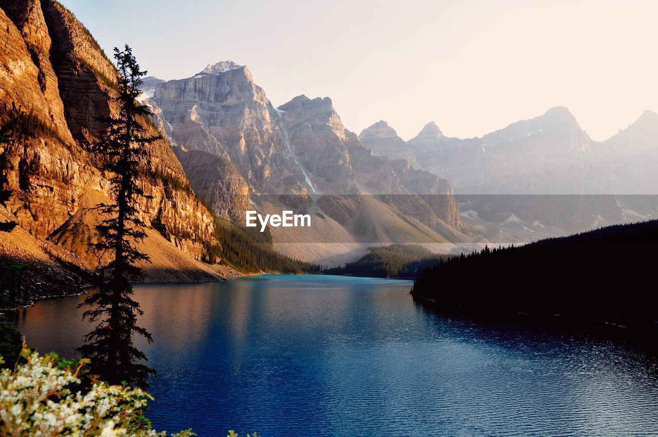 Scenic view of lake by mountains against sky