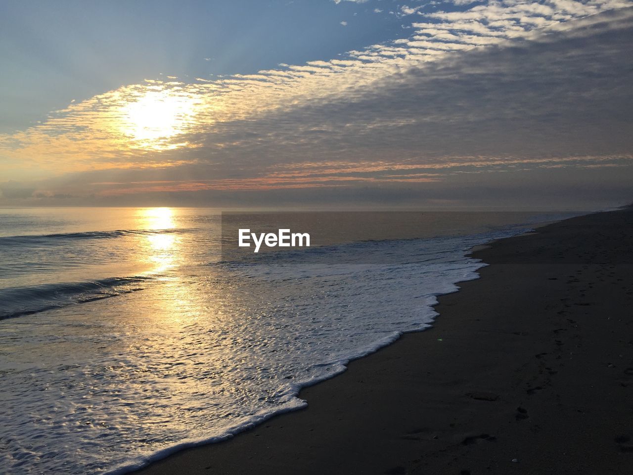 SCENIC VIEW OF BEACH AT SUNSET