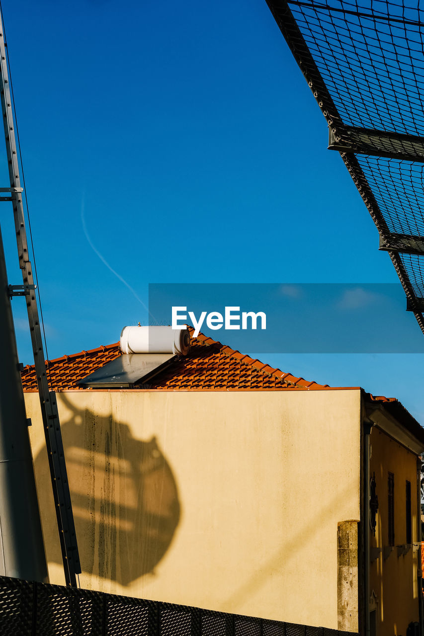 LOW ANGLE VIEW OF ROOF AND BUILDING AGAINST SKY