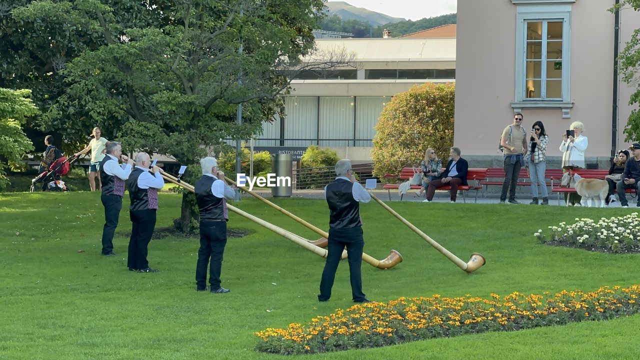 group of people, plant, men, architecture, building exterior, grass, built structure, lawn, large group of people, nature, day, tree, crowd, adult, women, building, green, leisure activity, lifestyles, child, sports, outdoors, full length, standing