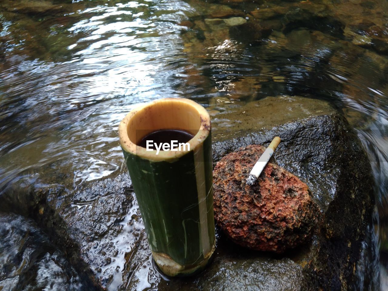 High angle view of coffee on rock by river