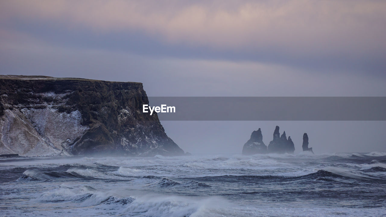 View of rock formation in sea against sky