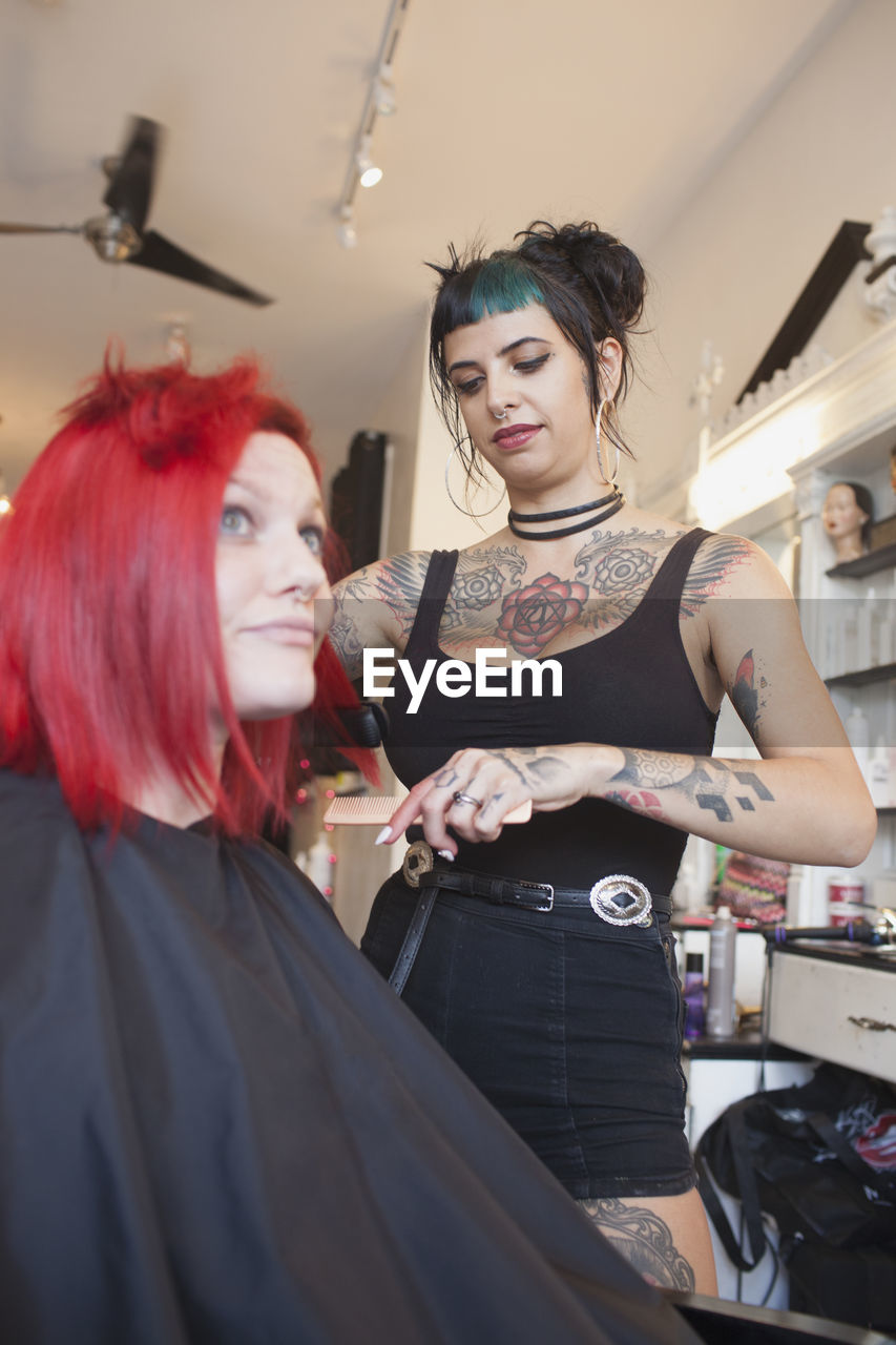 A hair dresser styling a customer's hair.