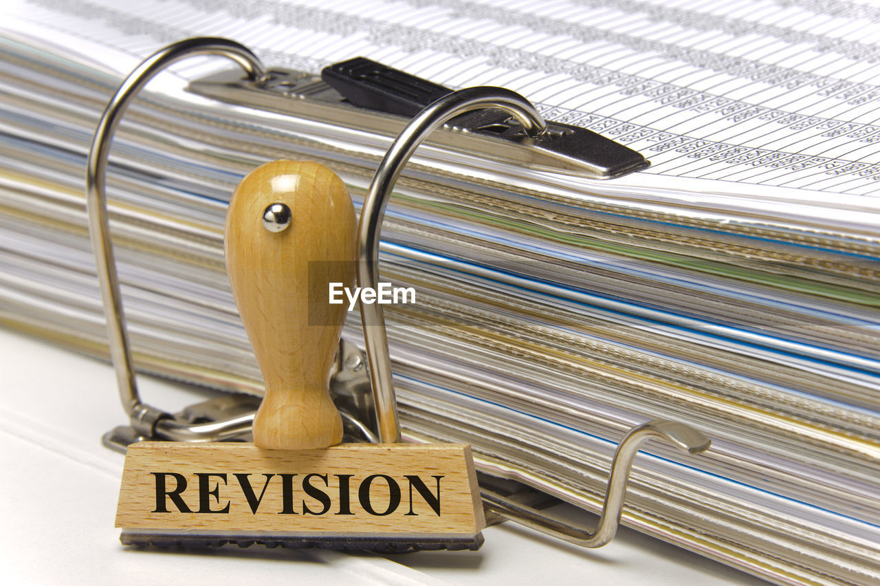 Close-up of revision stamp by documents on table