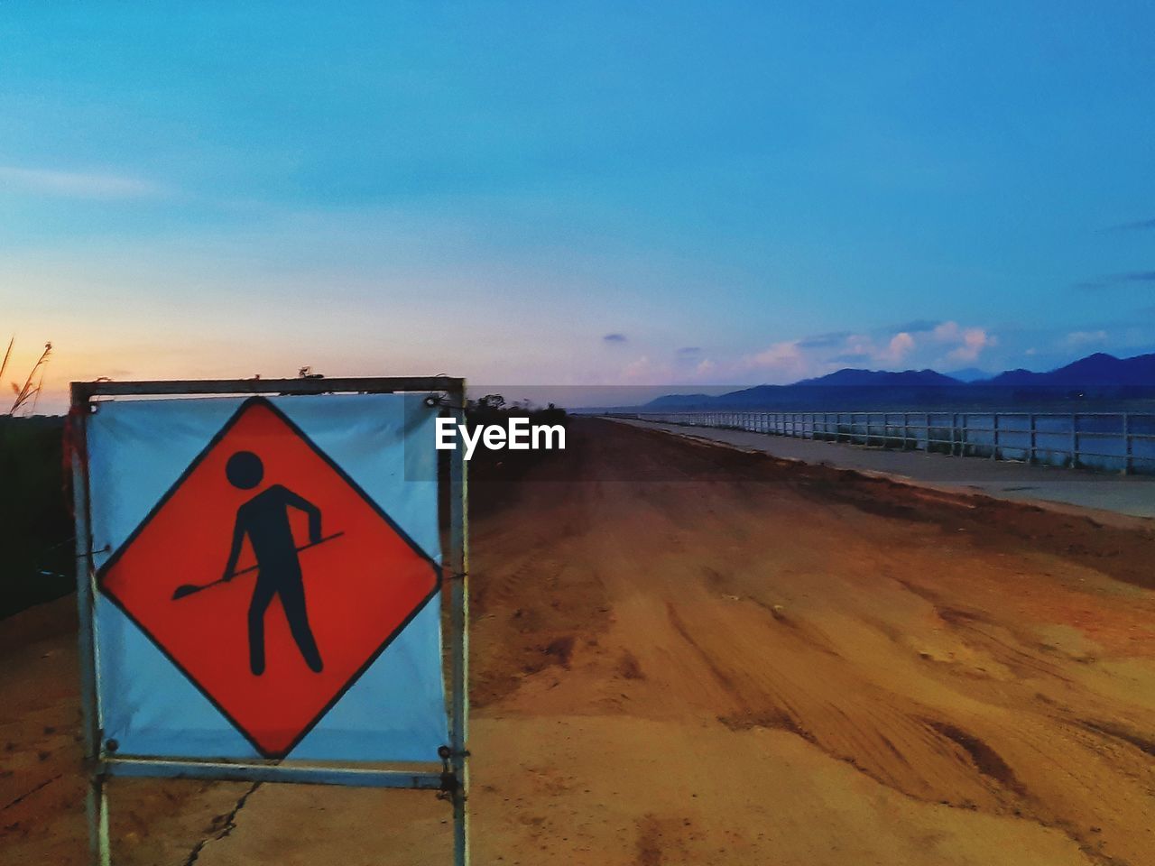 ROAD SIGN ON BEACH AGAINST SKY