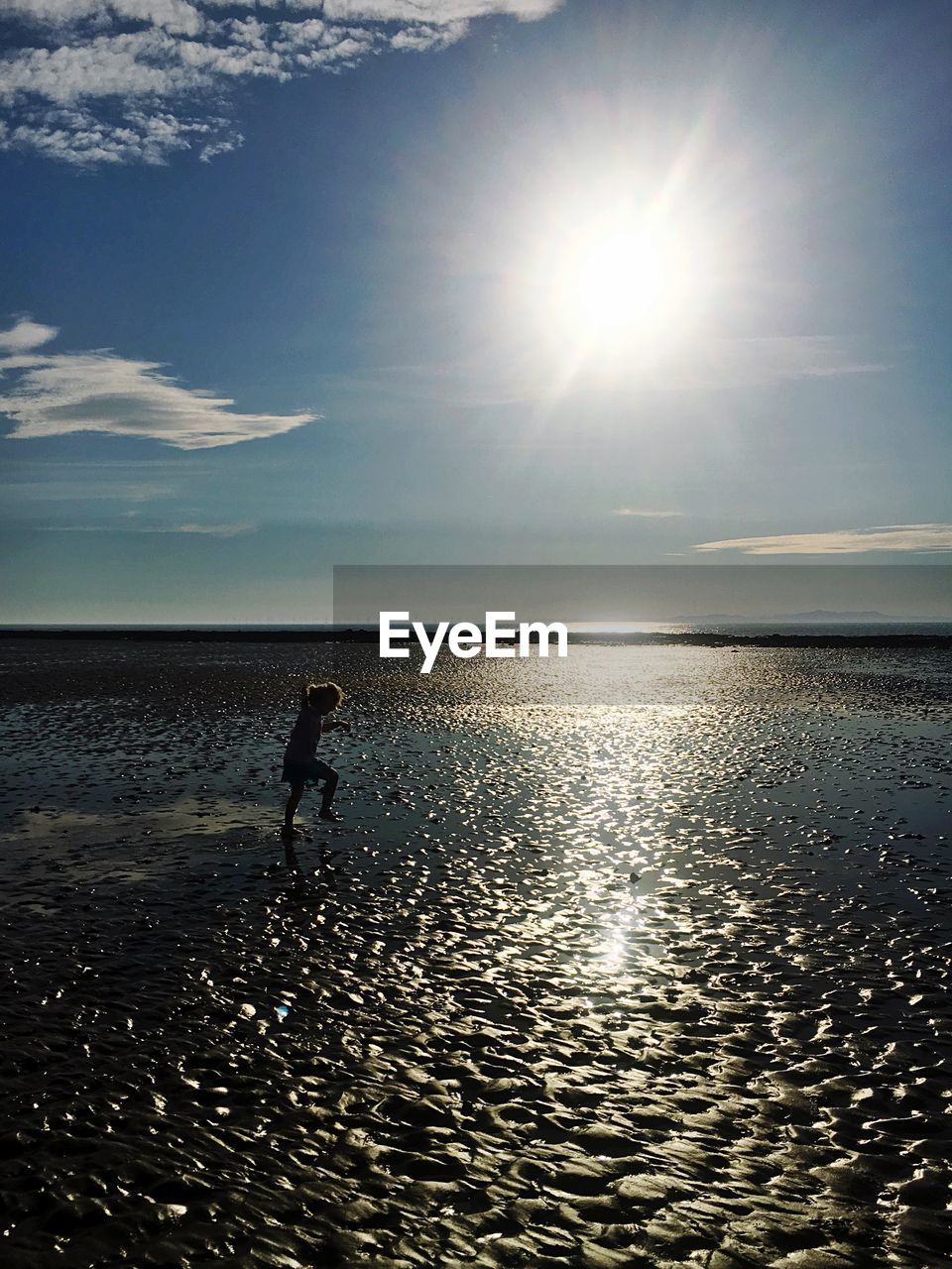 Girl at wet beach on sunny day