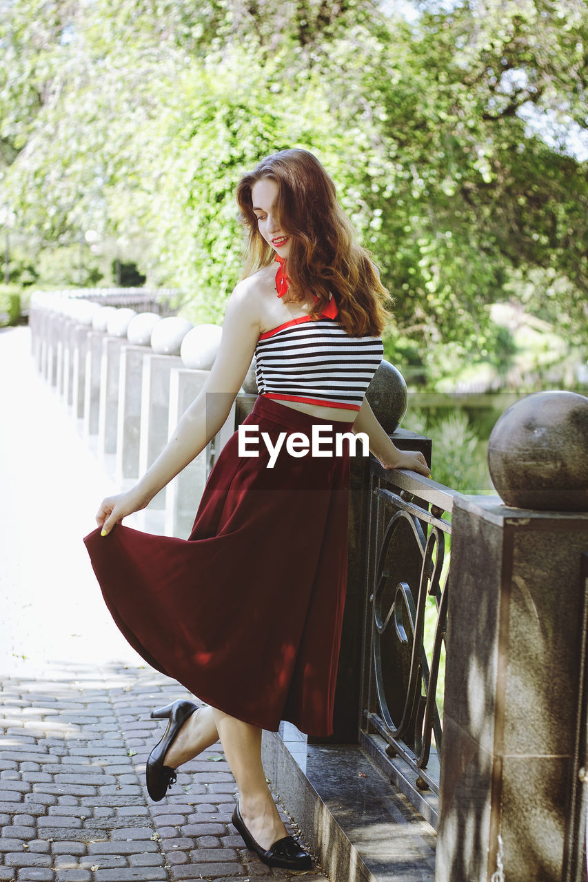 Rear view of woman standing against trees