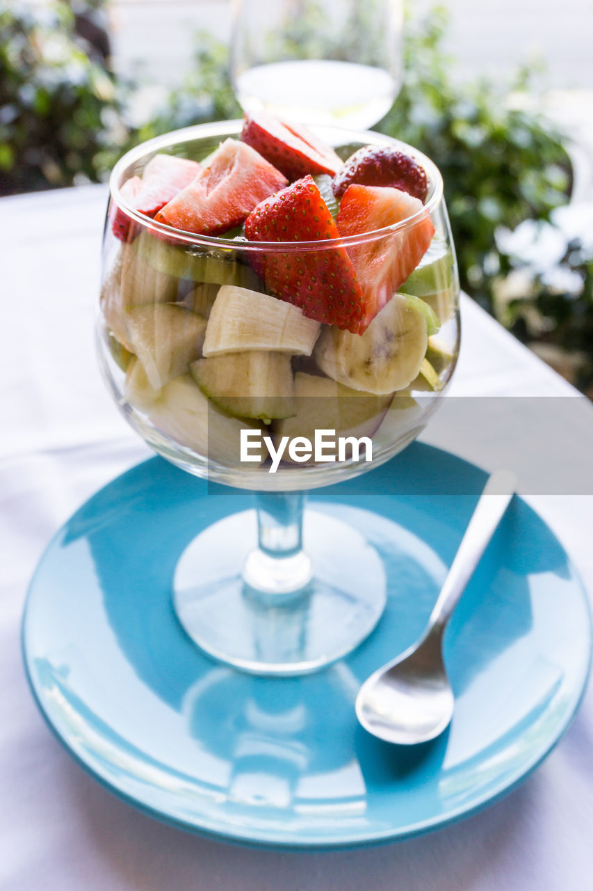 Close-up of fruit salad served in wineglass on table