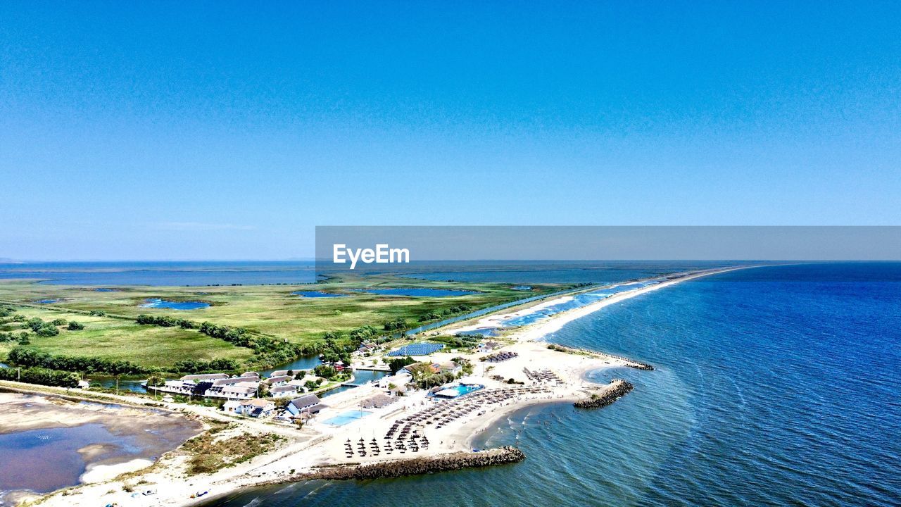 water, sea, coast, sky, ocean, blue, scenics - nature, nature, land, beach, horizon, shore, beauty in nature, day, horizon over water, clear sky, bay, high angle view, vacation, travel destinations, travel, no people, tranquility, tranquil scene, outdoors, copy space, sunny, transportation, aerial photography, idyllic, environment, sunlight, coastline, landscape, tourism, aerial view, holiday, nautical vessel, trip, architecture, non-urban scene
