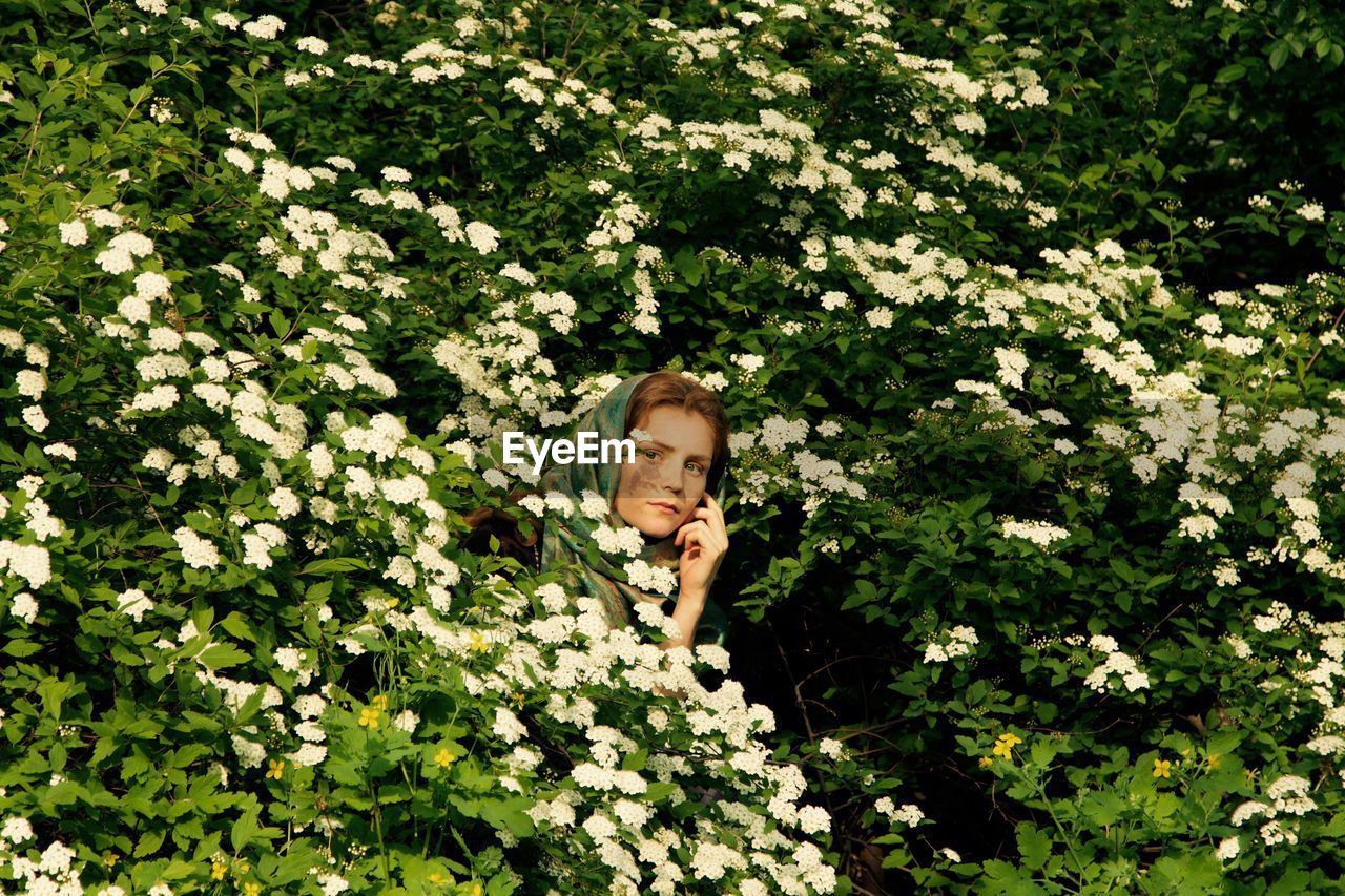 Close-up of young woman amidst flowers