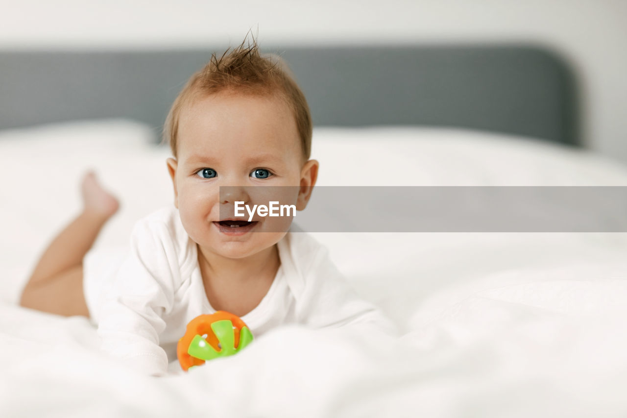 Portrait of cute baby lying down on bed