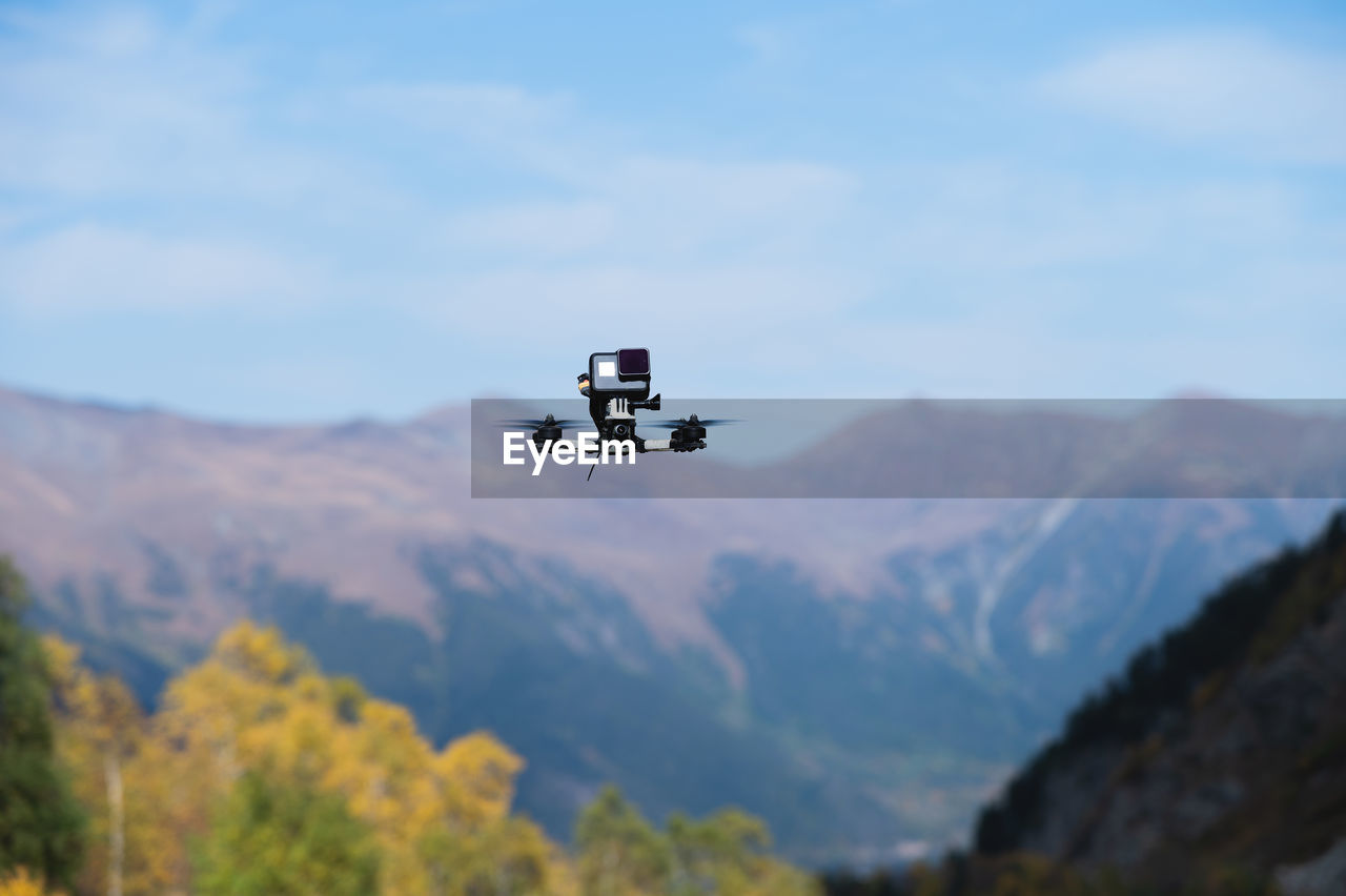 Drone with an action camera films mountains in flight. close-up of an unmanned device, fpv with