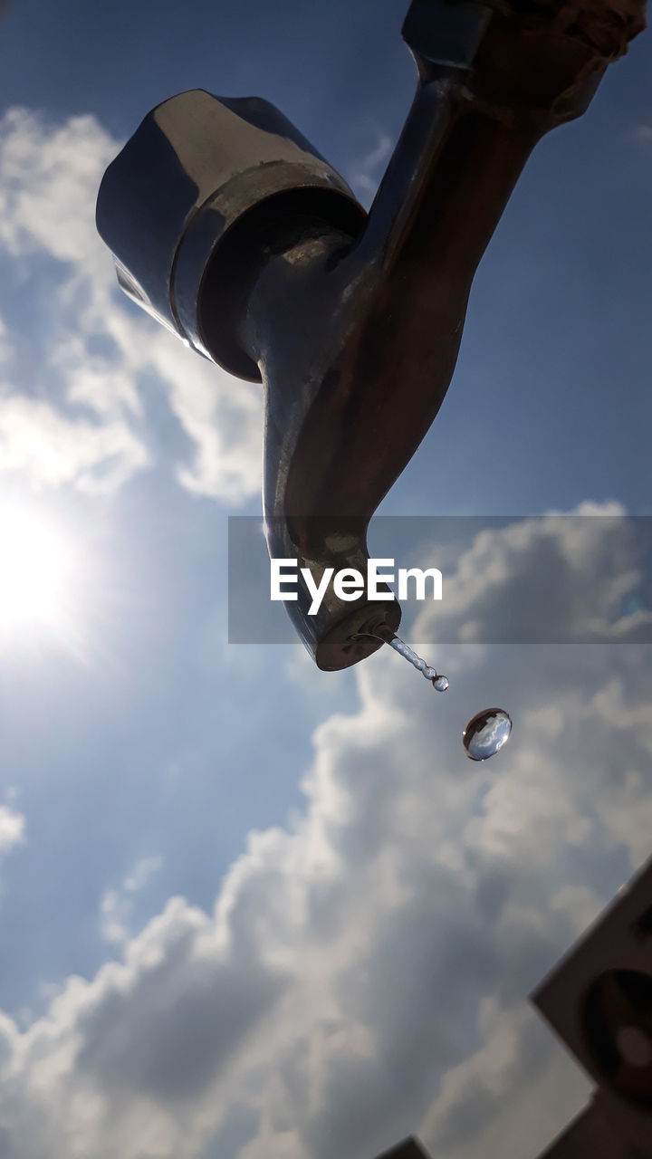 Close-up of tap against sky