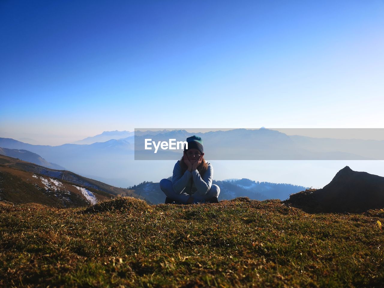 Sitting on mountain against sky