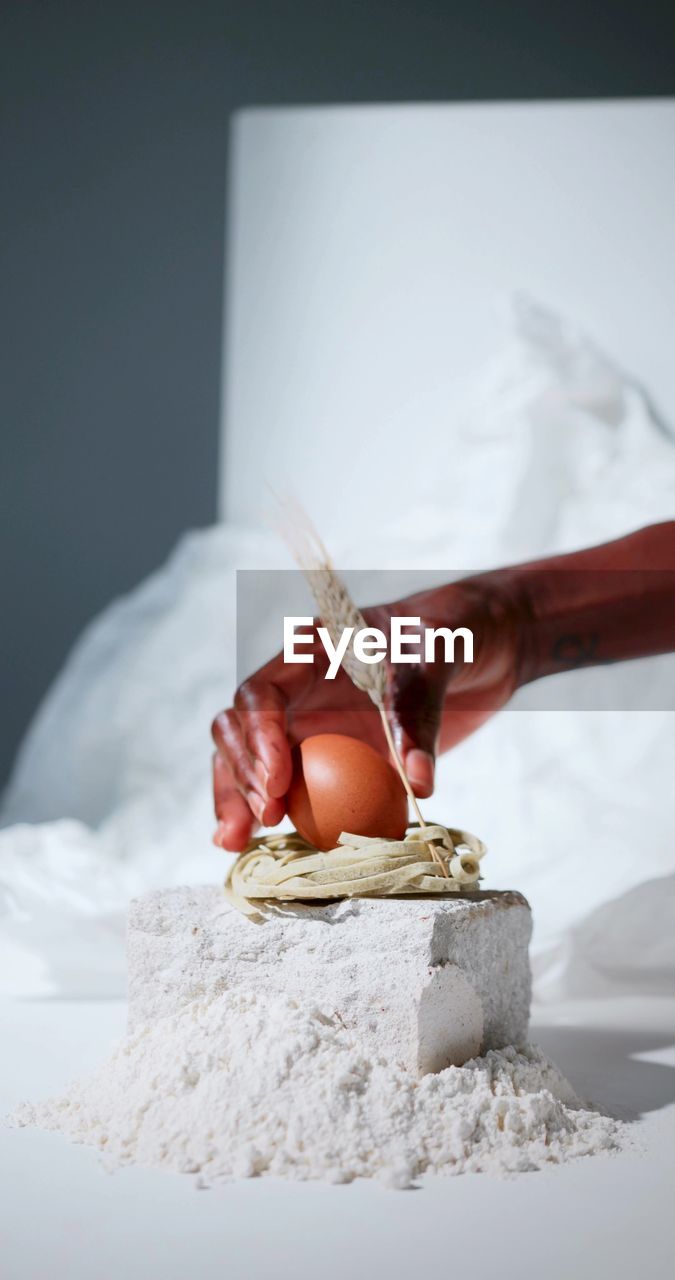 A photo of a hand which is taking an egg